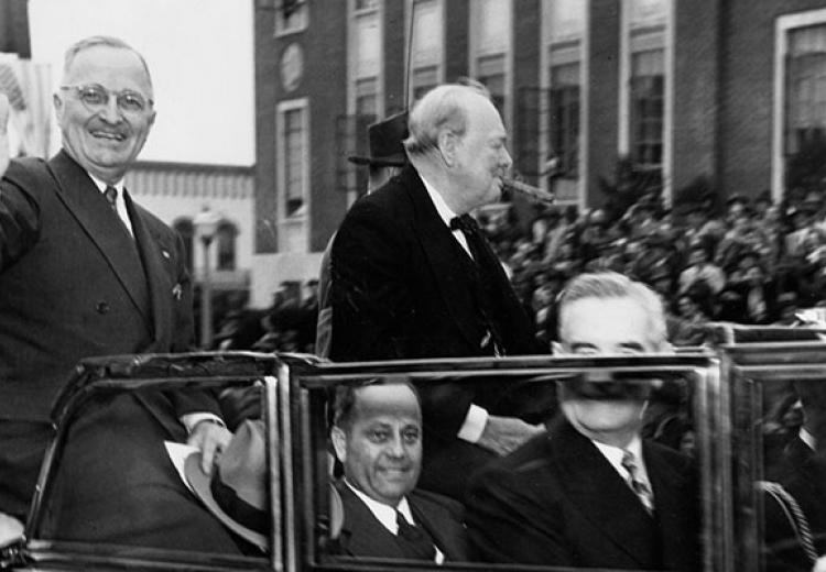 Truman waves from convertible as Churchill sits next to him smoking a cigar
