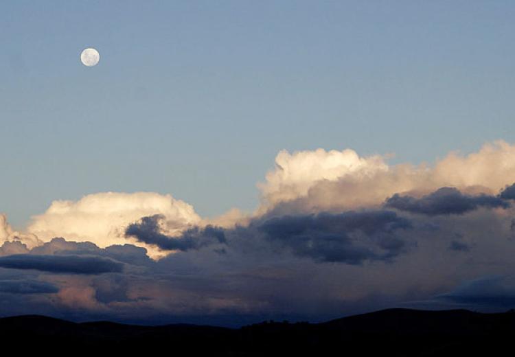 Moon over cumulus clouds