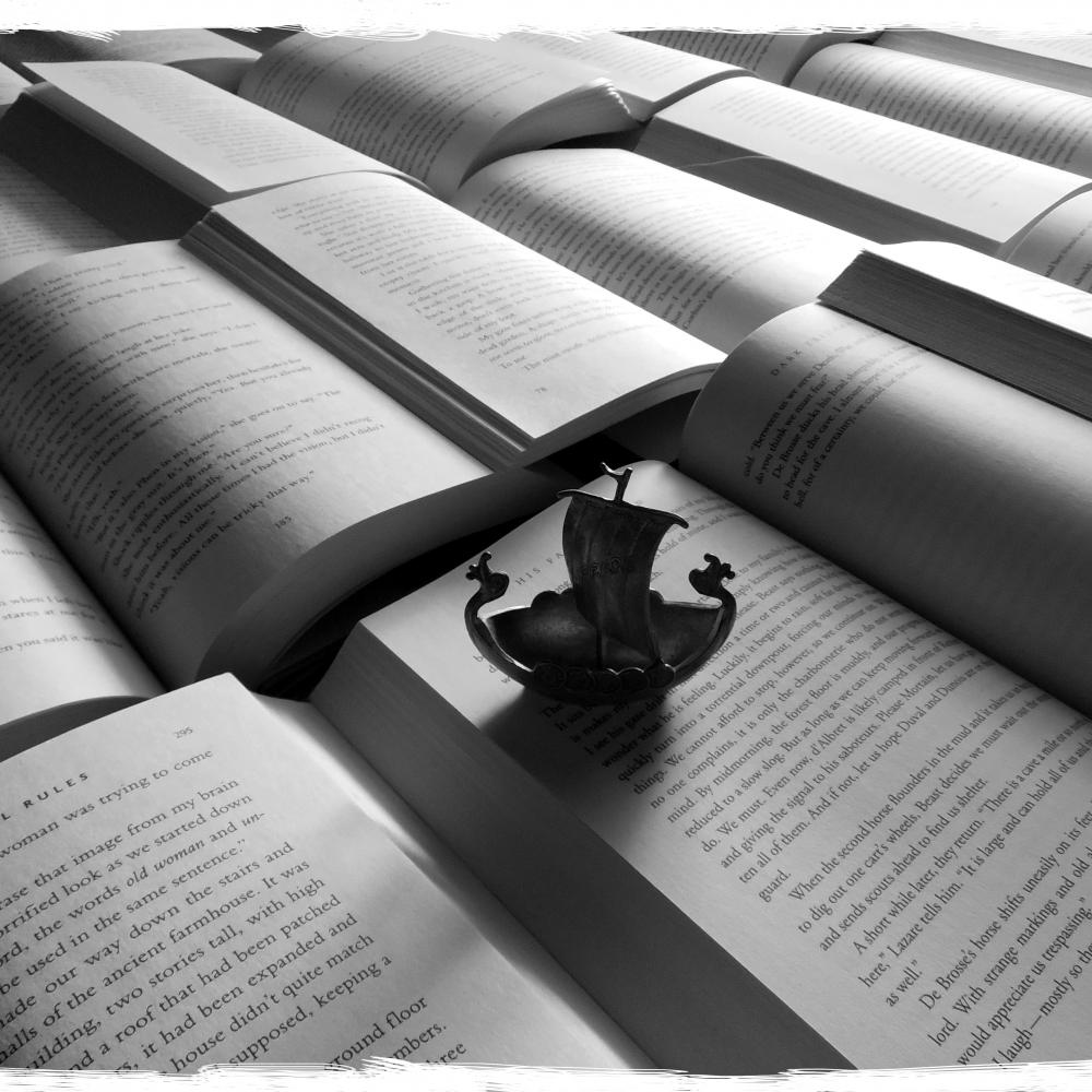 Small model boat resting on top of an open book