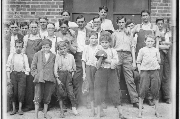 B&W image of young workers in front of brick building