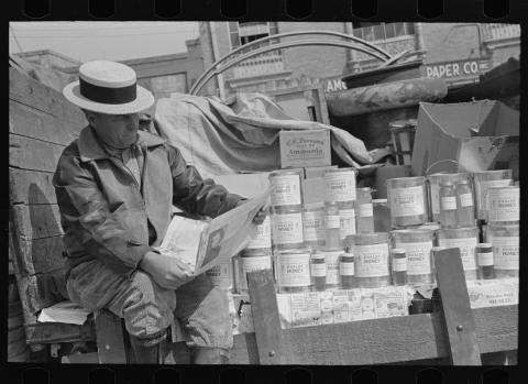 Honey peddler reading newspaper in market, San Antonio, Texas