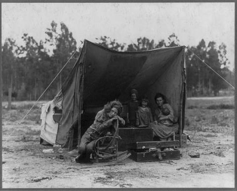 Photo shows Florence Thompson with several of her children in a tent shelter as part of the "Migrant Mother" series.