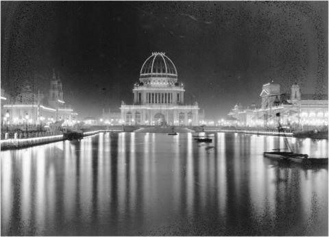 Domed building surrounded by lights, reflected in a pool of water