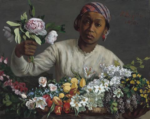 Black woman in colorful headscarf and white blouse holds handful of flowers and is surrounded by many colorful blooms. She looks directly at the viewer. 