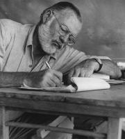 Ernest Hemingway Writing at his campsite in Kenya.