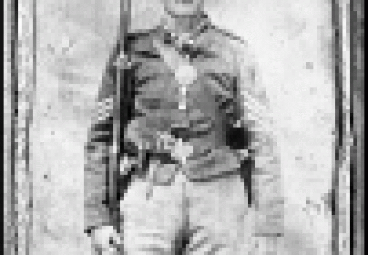 Soldier holding a rifle at his side, wearing a baggy federal uniform and flat cap