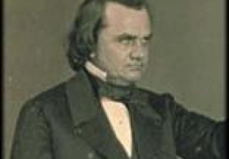 Douglas in a black suit and white shirt, hair combed back, reaching out his arm to the side and looking to his left
