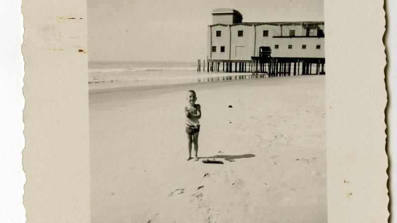 Photograph, child on 30th St. beach with Avalon Pier visible in background, 1945