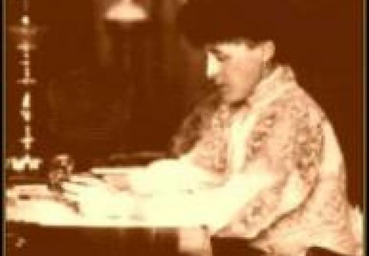 Sepia-colored photograph of Edith Wharton at her writing desk.