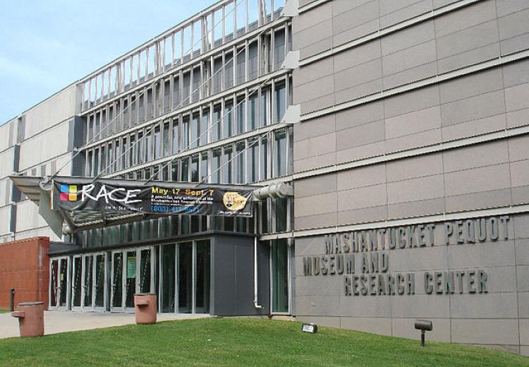 Colored photo of the exterior front entrance to the Pequot Museum with 