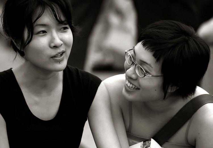 Two young women smiling in conversation