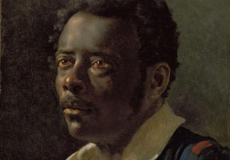 Portrait of Black man in loose collared shirt and blue jacket