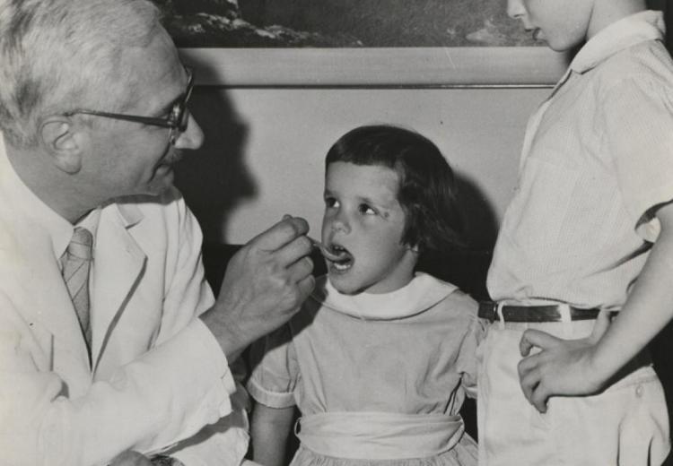 Dr. Sabin administers his oral polio vaccine in sweet cherry syrup.