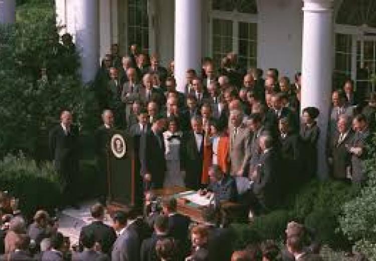 As President Lyndon B. Johnson signed the legislation authorizing the creation of NEH, more than two hundred people looked on, including First Lady Claudia “Lady Bird” Johnson, Gregory Peck, Dumas Malone, Ansel Adams, Ralph Ellison, Walter Gropius, and Paul Mellon.